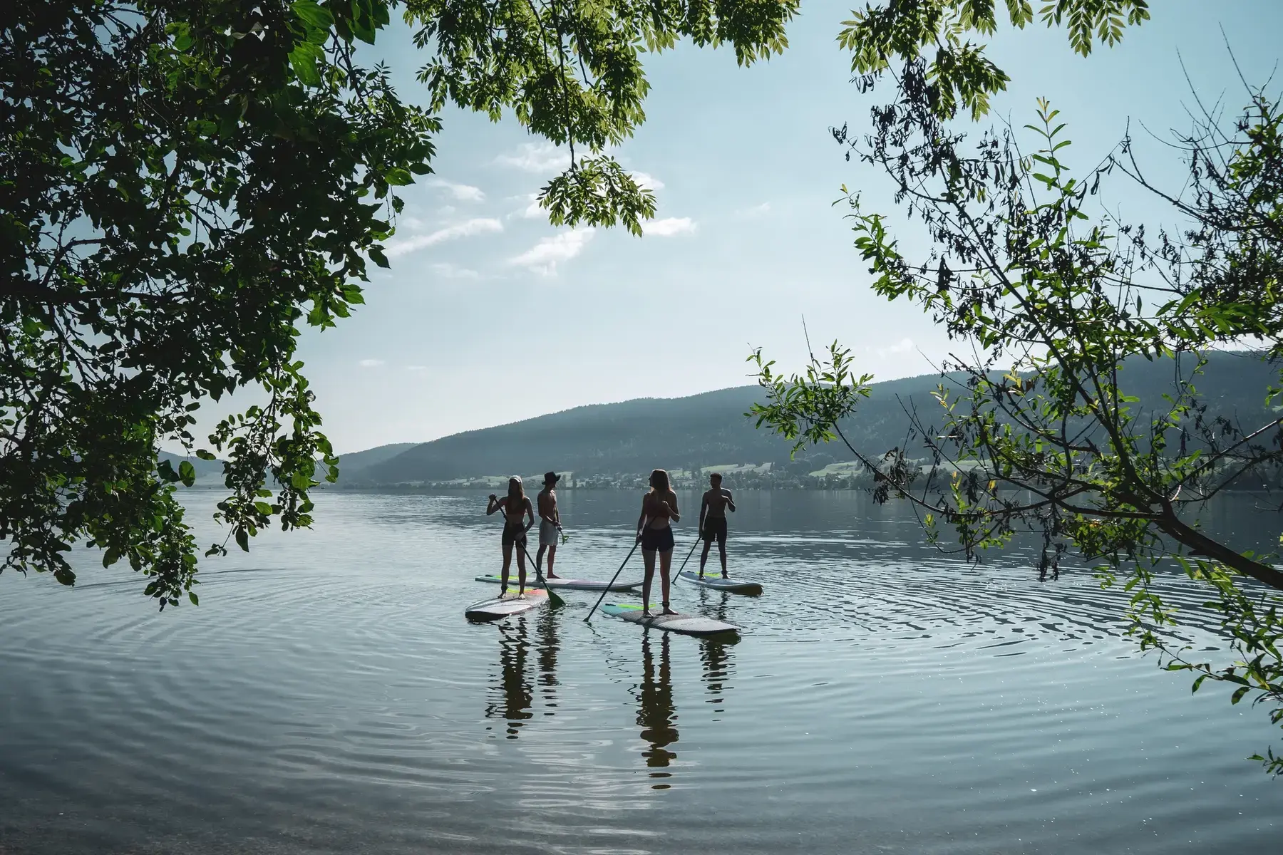 Groupe de paddlers encadré par les arbres sur le Lac de Joux.